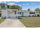 Charming single-story home featuring a covered carport, blue entry door, and tidy front yard at 5805 S Hubert Ave, Tampa, FL 33616