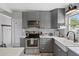 A well-equipped kitchen showcasing gray cabinetry, stainless steel appliances, and modern countertops at 5805 S Hubert Ave, Tampa, FL 33616
