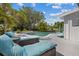 Resort-style backyard with inviting lounge chairs next to the sparkling swimming pool surrounded by lush landscaping at 5805 S Hubert Ave, Tampa, FL 33616