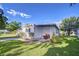 Exterior view of a home featuring a landscaped yard and a white exterior at 6044 Alpine Dr, Zephyrhills, FL 33542