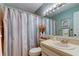 Cozy bathroom with a sink and shower featuring a colorful, striped curtain at 612 Fairmont Ave # D, Safety Harbor, FL 34695