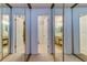 Mirrored closet doors revealing tiled en suite bathrooms with vanities and updated lighting fixtures at 612 Fairmont Ave # D, Safety Harbor, FL 34695