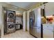Bright kitchen includes a stainless steel refrigerator and stacked washer/dryer at 612 Fairmont Ave # D, Safety Harbor, FL 34695