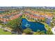 Stunning aerial view of townhomes, lush landscaping, a serene pond with a fountain, and a bridge in the distance at 6191 Bahia Del Mar Blvd # 204, St Petersburg, FL 33715