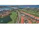 Expansive aerial view showcasing a community with terracotta roofs, manicured golf courses, and waterfront scenery at 6191 Bahia Del Mar Blvd # 204, St Petersburg, FL 33715