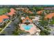 Aerial view of the community showcasing the pool area, landscaped grounds, and residences with terracotta roofs at 6191 Bahia Del Mar Blvd # 204, St Petersburg, FL 33715