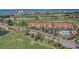 Aerial view of a community with terracotta roofs, manicured golf courses, and serene waterfront in the background at 6191 Bahia Del Mar Blvd # 204, St Petersburg, FL 33715