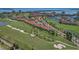 Breathtaking aerial view of a lush golf course community with red-tiled roofs, serene ponds, and waterfront views at 6191 Bahia Del Mar Blvd # 204, St Petersburg, FL 33715