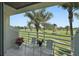 Relax on this peaceful balcony with seating and green golf course views framed by swaying palm trees at 6191 Bahia Del Mar Blvd # 204, St Petersburg, FL 33715