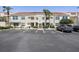 Exterior of condo building with red tile roof, parking area, and manicured landscaping at 6191 Bahia Del Mar Blvd # 204, St Petersburg, FL 33715