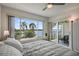 Bright bedroom with large windows showcasing tropical waterfront views and access to a private balcony at 6361 Bahia Del Mar Blvd # 205, St Petersburg, FL 33715