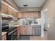 Kitchen with wooden cabinets, stainless steel appliances, and a view to the living room at 6361 Bahia Del Mar Blvd # 205, St Petersburg, FL 33715