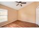 This bedroom features wood floors, neutral walls, and a large window for natural light at 6711 Thackston Dr, Riverview, FL 33578