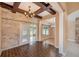 Dining room features stone wall, exposed beams, wood-look tile flooring, and access to the backyard at 6711 Thackston Dr, Riverview, FL 33578