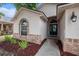 Front entrance featuring arched window and brick accents, leading to a welcoming front door at 6711 Thackston Dr, Riverview, FL 33578
