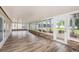 Screened porch with wood-look floors and windows offering views of the yard at 6711 Thackston Dr, Riverview, FL 33578
