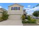 Inviting two-story home featuring an attached garage and well-manicured front yard at 10101 Mangrove Well Rd, Ruskin, FL 33573