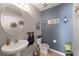 Cozy half bathroom featuring neutral paint, decorative accents, and an oval mirror at 10101 Mangrove Well Rd, Ruskin, FL 33573