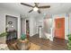 Hallway featuring wood floors, a staircase, and an orange door with unique wall decor at 10101 Mangrove Well Rd, Ruskin, FL 33573