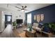 Comfortable living room with wood floors, ceiling fan, blue accent wall and entertainment center at 10101 Mangrove Well Rd, Ruskin, FL 33573