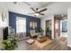 Living room with ceiling fan, wood floors, blue accent wall and a decorated sitting area at 10101 Mangrove Well Rd, Ruskin, FL 33573