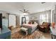 Main bedroom with a ceiling fan, barn door closet, a sitting chair and an area rug at 10101 Mangrove Well Rd, Ruskin, FL 33573
