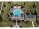 Aerial view of a sparkling blue community pool surrounded by lounge chairs and verdant landscaping at 10101 Mangrove Well Rd, Ruskin, FL 33573