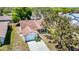 Aerial shot of the home, showcasing mature trees, manicured lawn, and attached garage at 10819 Los Santos Dr, Port Richey, FL 34668