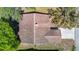 A close aerial shot focuses on the roof of the home, showing its architecture and relation to the surrounding yard and neighborhood at 10819 Los Santos Dr, Port Richey, FL 34668