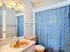 Traditional bathroom featuring vanity with an oval sink, toilet, and a blue shower curtain at 10819 Los Santos Dr, Port Richey, FL 34668