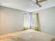 A bedroom featuring large windows with curtains and neutral walls, offering a bright space at 10819 Los Santos Dr, Port Richey, FL 34668