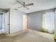Bedroom featuring multiple doorways, carpeted floors and a ceiling fan at 10819 Los Santos Dr, Port Richey, FL 34668