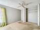 Bedroom featuring an open closet, ceiling fan, and a large window with green curtains at 10819 Los Santos Dr, Port Richey, FL 34668