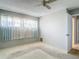 Spacious bedroom showcasing a window with curtains and a ceiling fan at 10819 Los Santos Dr, Port Richey, FL 34668