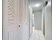 Hallway with multiple closet doors and white tile floors at 10819 Los Santos Dr, Port Richey, FL 34668