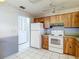 Traditional kitchen with wood cabinets, white appliances, and tile flooring at 10819 Los Santos Dr, Port Richey, FL 34668