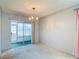 Spacious living room with carpet flooring, sliding glass door, and modern chandelier at 10819 Los Santos Dr, Port Richey, FL 34668