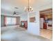 Bright living room showcasing a brick fireplace, vintage chandelier, and view into the adjacent kitchen at 10819 Los Santos Dr, Port Richey, FL 34668