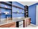 Charming dining area with custom blue shelving, granite counters, and a mini fridge at 14812 Boulder Pass Pl, Wimauma, FL 33598