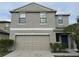Two-story home featuring a neutral gray exterior, a two-car garage, and well-maintained landscaping at 14812 Boulder Pass Pl, Wimauma, FL 33598