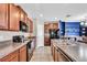 Well-equipped kitchen with granite counters, stainless steel appliances and center island overlooking the dining area at 14812 Boulder Pass Pl, Wimauma, FL 33598