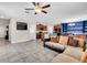 Open-concept living room flows into the kitchen, with tiled floors and a large sectional couch at 14812 Boulder Pass Pl, Wimauma, FL 33598