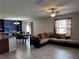An open living space with a comfortable sectional couch, adjacent to a dining area with distinctive blue accent wall at 14812 Boulder Pass Pl, Wimauma, FL 33598