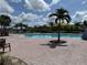 Community pool featuring a large deck, a palm tree, lounge chairs, and beautiful Florida sunshine at 14812 Boulder Pass Pl, Wimauma, FL 33598