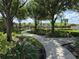 Landscaped walkway through the community featuring mature trees and lush tropical plants at 14812 Boulder Pass Pl, Wimauma, FL 33598