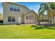 Lush green backyard with a screened lanai, mature trees, and views of the home's architecture at 15714 Ibisridge Dr, Lithia, FL 33547
