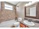Tiled bathroom featuring a shower and bath combo with granite counters, and decorative framed mirror at 15714 Ibisridge Dr, Lithia, FL 33547