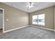 Neutral bedroom with new carpet, ceiling fan, white trim, and a bright window at 15714 Ibisridge Dr, Lithia, FL 33547