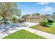 Exterior of a well-landscaped house with a spacious driveway and lush green lawn on a sunny day at 15714 Ibisridge Dr, Lithia, FL 33547