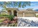 Inviting home exterior featuring a two-car garage, well-maintained landscaping, and a charming facade at 15714 Ibisridge Dr, Lithia, FL 33547